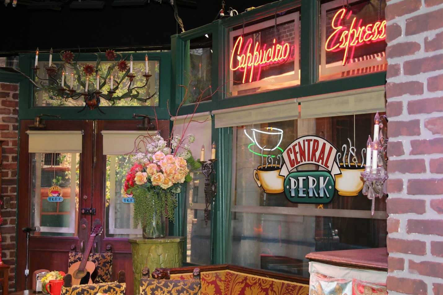 Cozy café interior with neon "Espresso" sign, hanging flowers and Central Perk logo