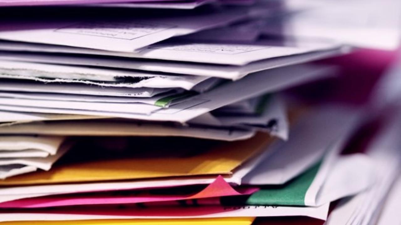 pile of papers representing the process of reporting