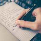 Photo of a hand writing in a notebook