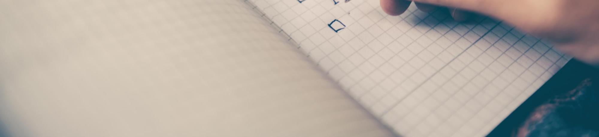 Photo of a hand writing in a notebook